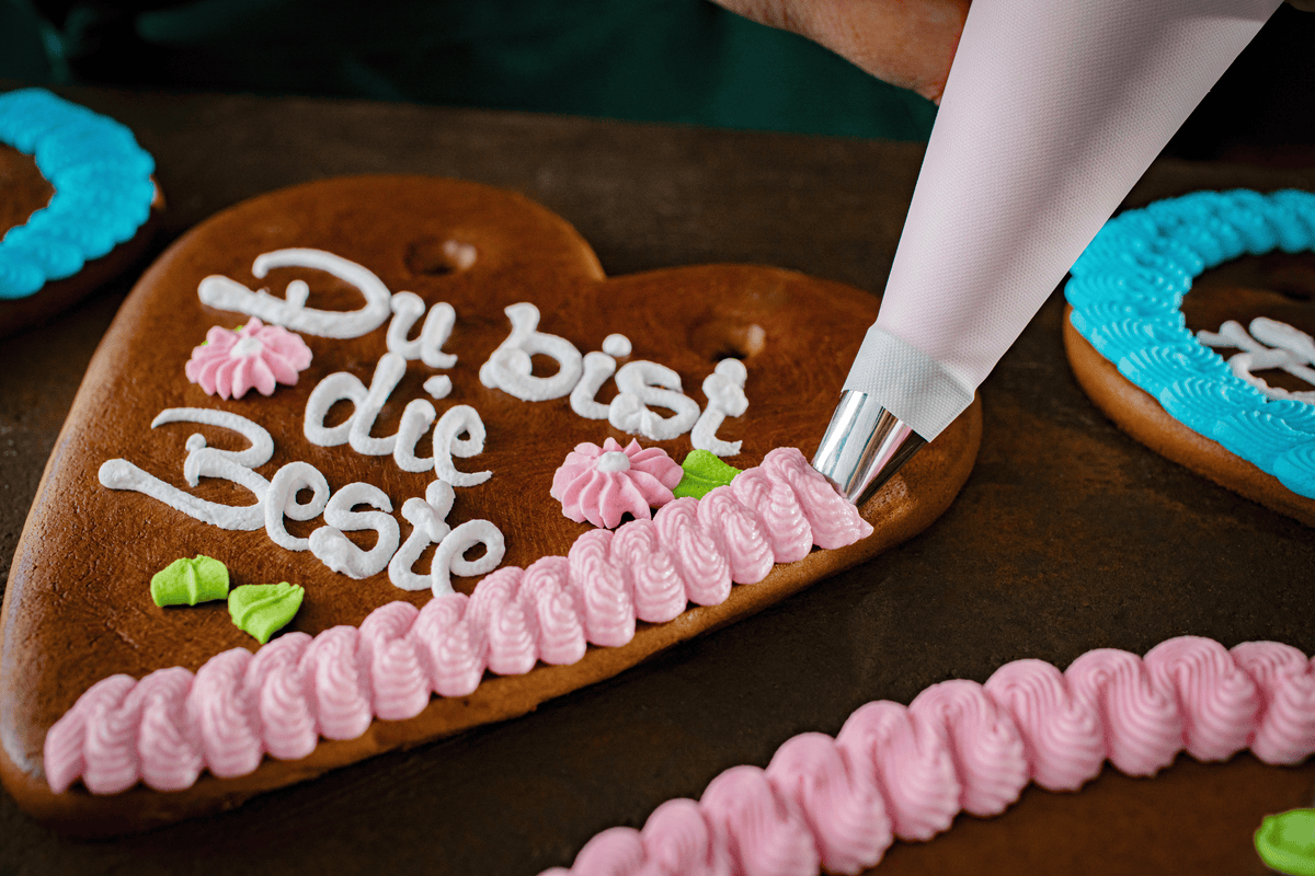 Ein Lebkuchenherz wird mit Zuckerguss verziert