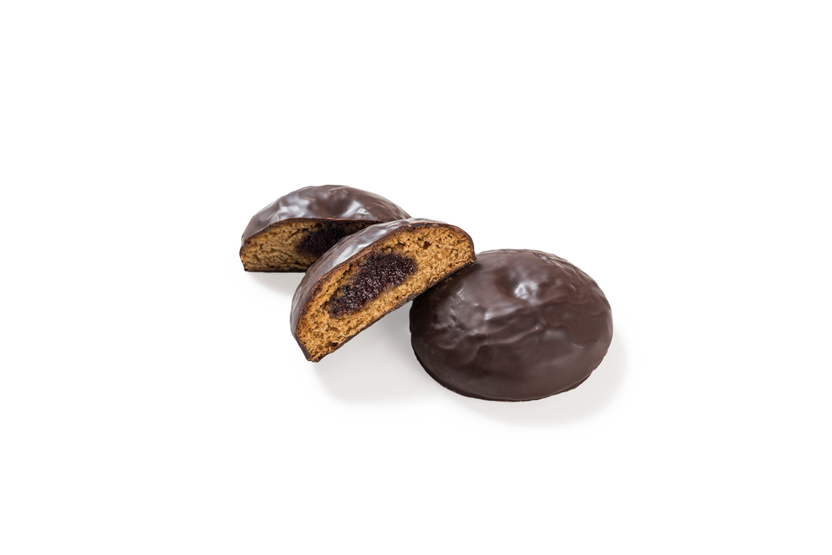 Produktaufnahme von runden Lebkuchen-Spezialitäten, sogenannten Kirschbomben.  Ein Stück liegt als Ganzes vor, während zwei weitere halbiert sind und den Blick auf das Innere mit einer dunklen Fruchtfüllung sowie den feinporigen Lebkuchen-Teig freigeben. Alle Stücke sind mit einer glänzenden Schicht dunkler Schokolade überzogen.