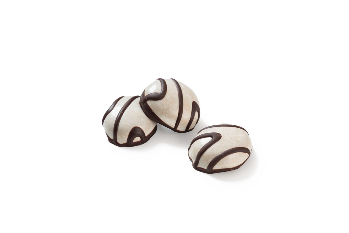 Produktaufnahme von drei Pfeffernüssen mit Schokoladendekor. Die runden Gebäckstücke sind mit einer hellen Zuckerglasur überzogen und mit feinen, dunklen Schokoladenstreifen verziert.