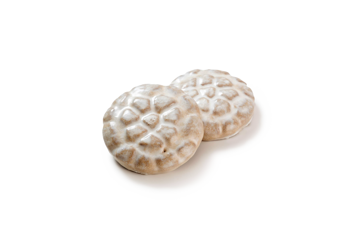 Produktaufnahme von zwei runden Lebkuchen, die durch ihre charakteristische, reliefartige Prägung an Steinpflaster erinnern. Beide Gebäckstücke sind vollständig mit einer dicken, glänzenden Zuckerglasur überzogen, die in die Vertiefungen des Musters fließt und dieses optisch hervorhebt.