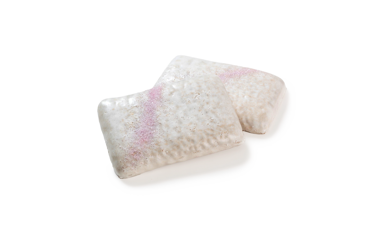 Produktaufnahme von zwei rechteckigen Lebkuchenstücken mit Zuckerglasur. Die Gebäckstücke sind vollständig mit einer dicken, weißen, Zuckerglasur überzogen. Ein markanter, diagonaler Streifen aus rosafarbenem Zuckerdekor ziert die Oberfläche beider Stücke.